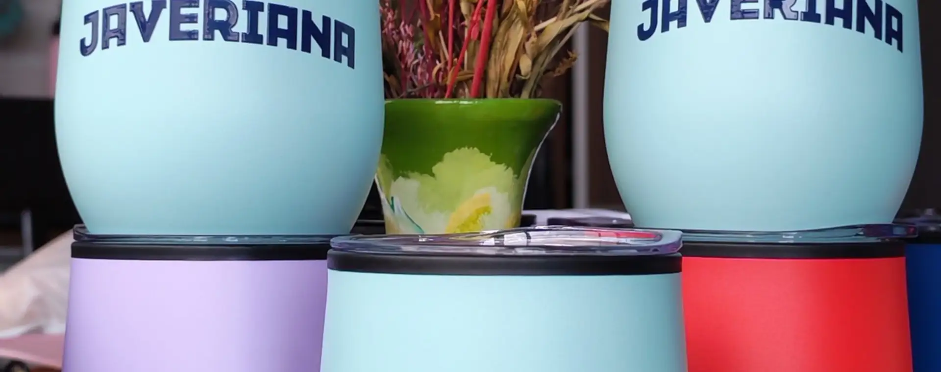 Vasos térmicos de colores pastel personalizados apilados junto a una caja kraft