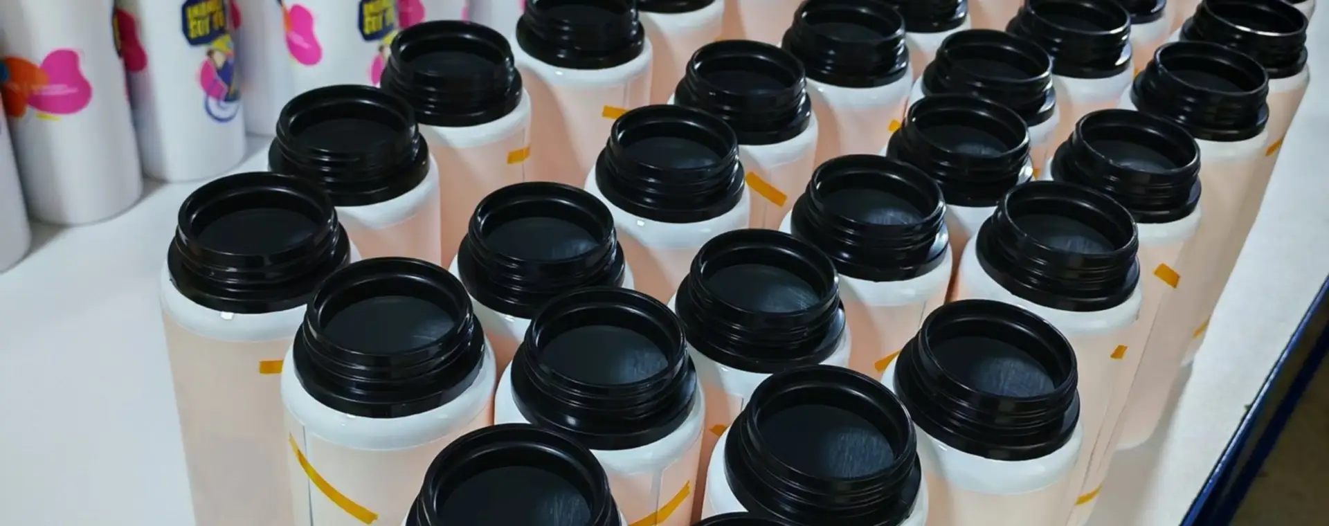 Lote de botellas deportivas blancas con tapa negra vistas desde arriba