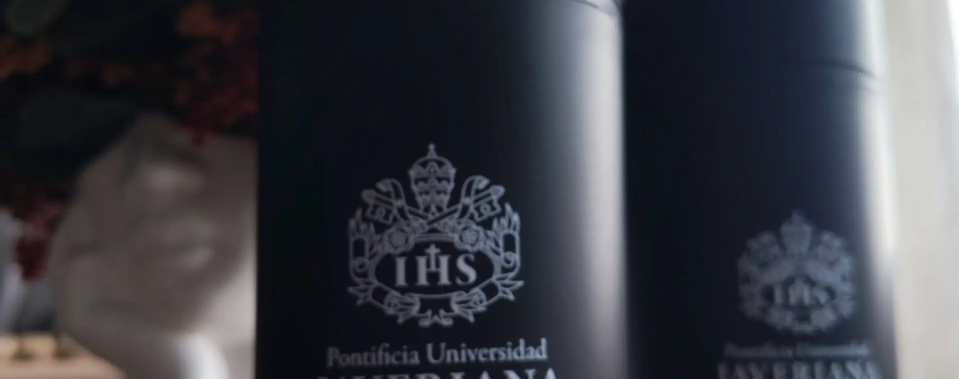 Termos negros con escudo grabado con láser sobre una mesa