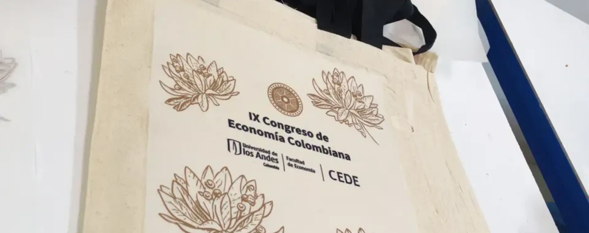 Prensa térmica aplicando un diseño DTF sobre una bolsa de tela en el taller