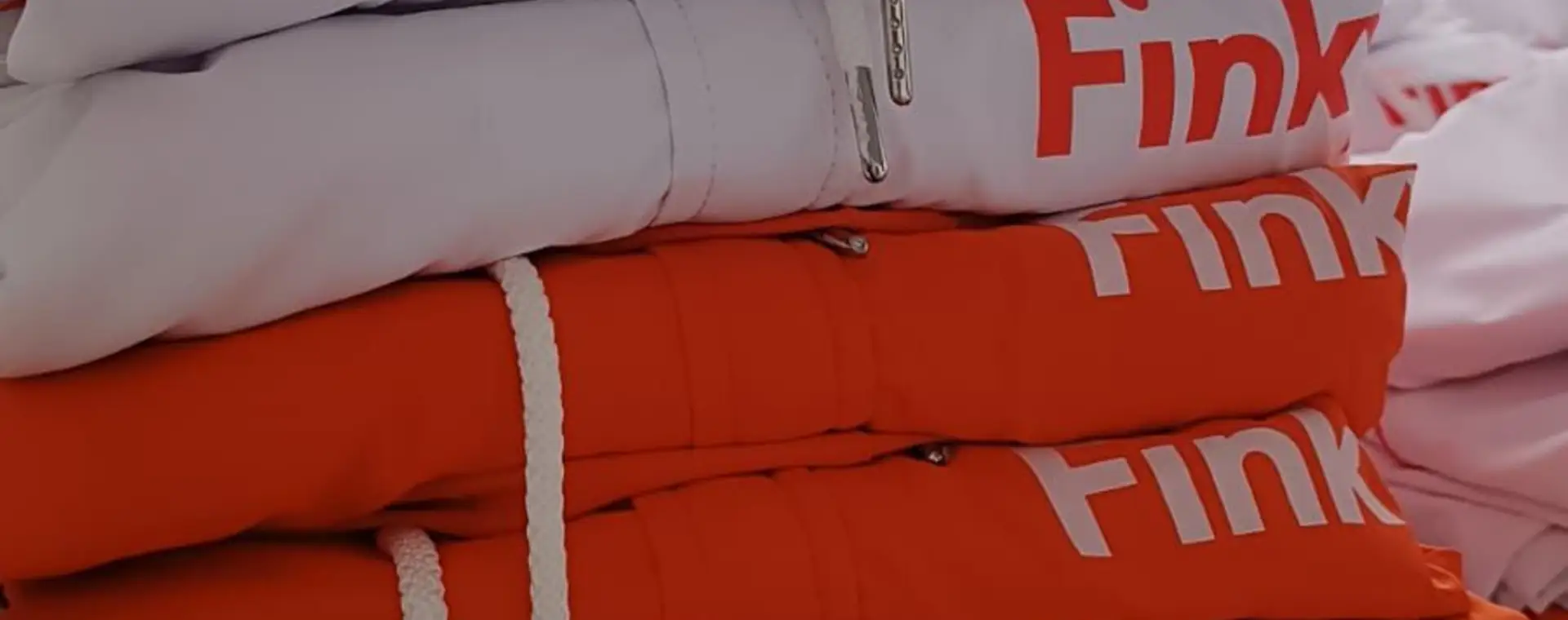 Buzos naranjas doblados con el logo estampado en blanco