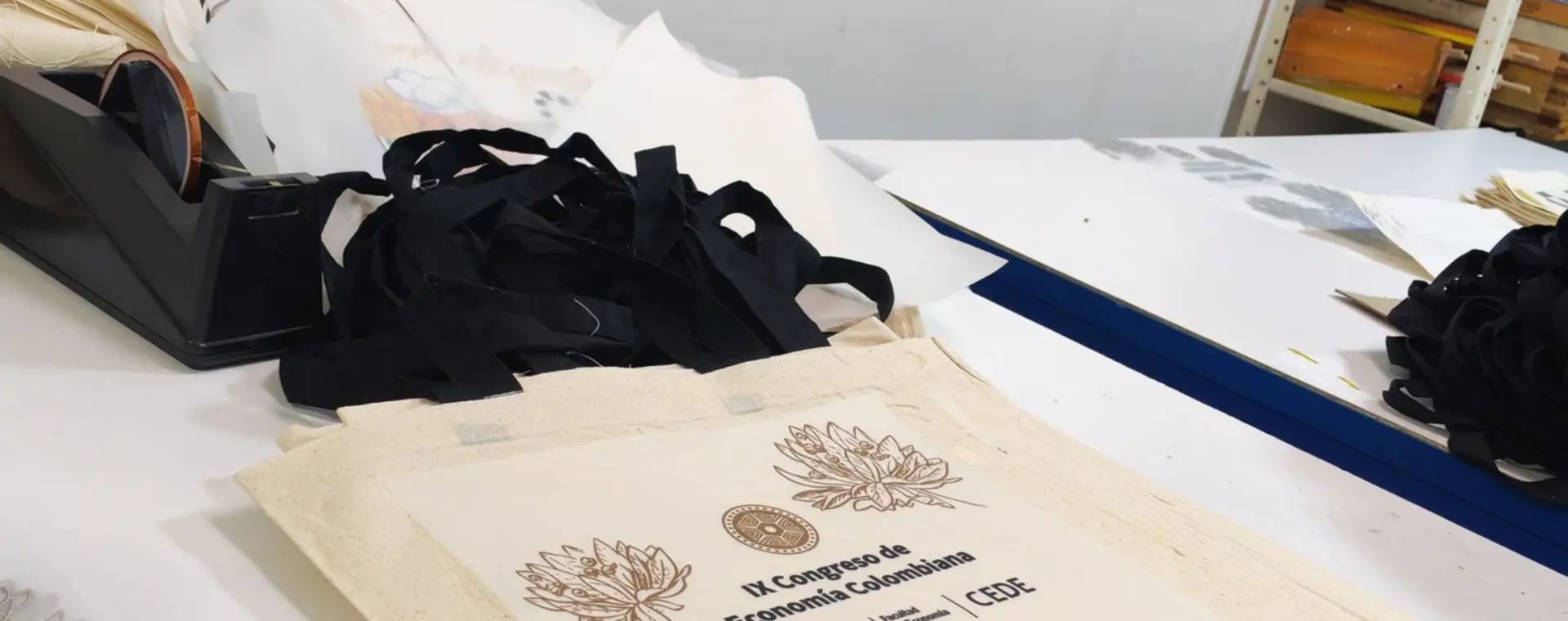 Bolsas de tela con diseño estampado sobre la mesa de trabajo del taller